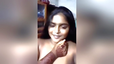 Chubby brunette girl shows her boobs in the bedroom